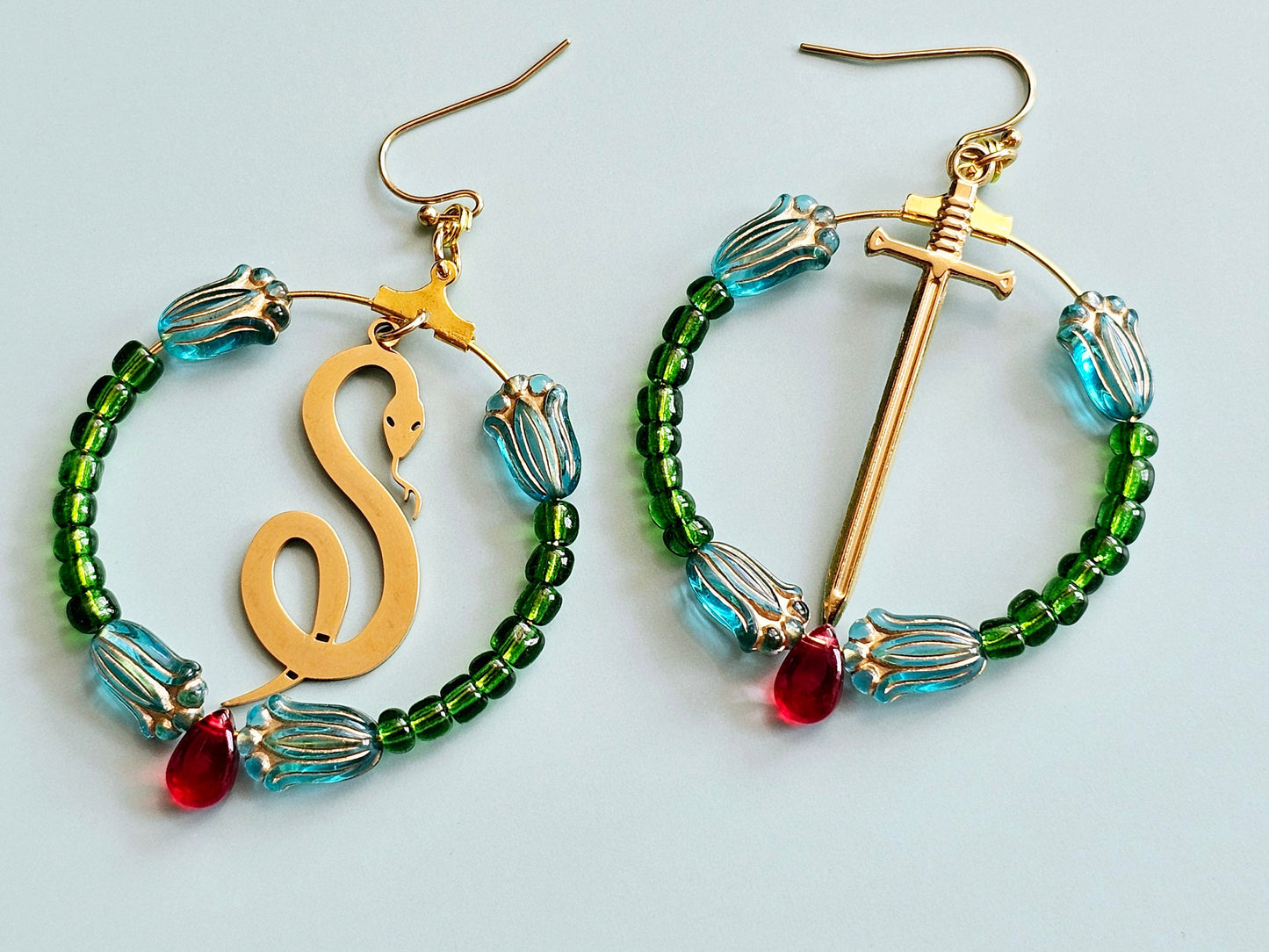 Snake hoop earrings sword hoop earrings with floral detail.