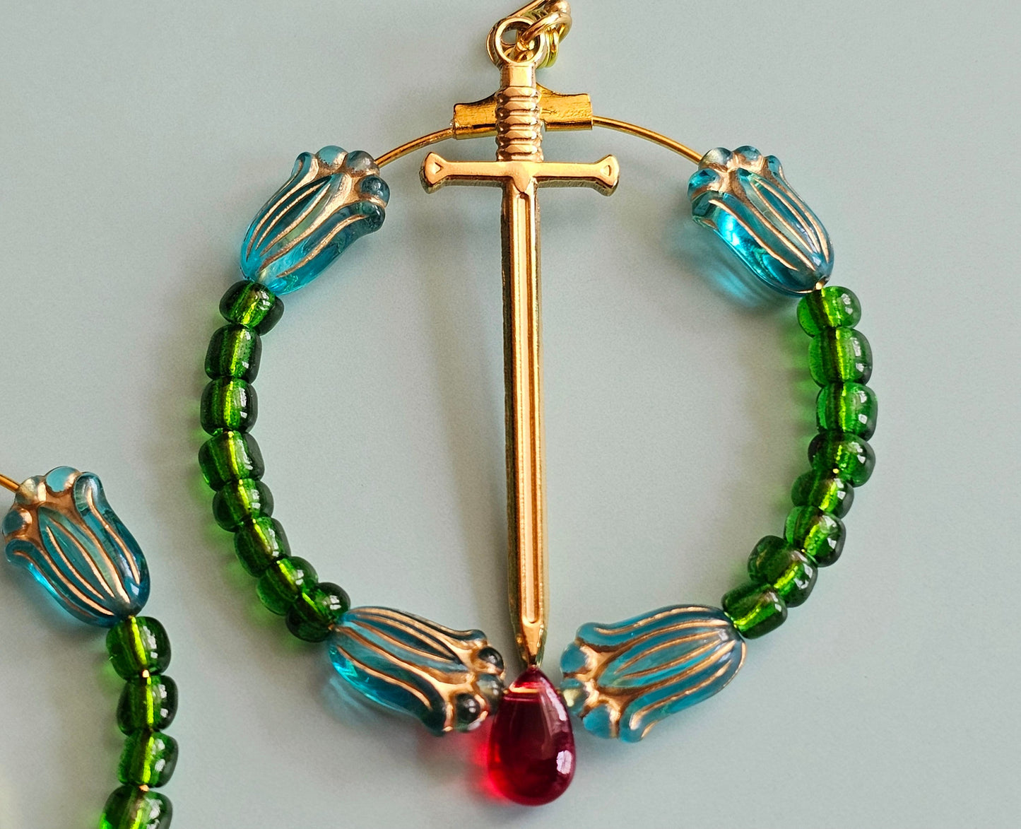 a necklace with a cross and beads on it