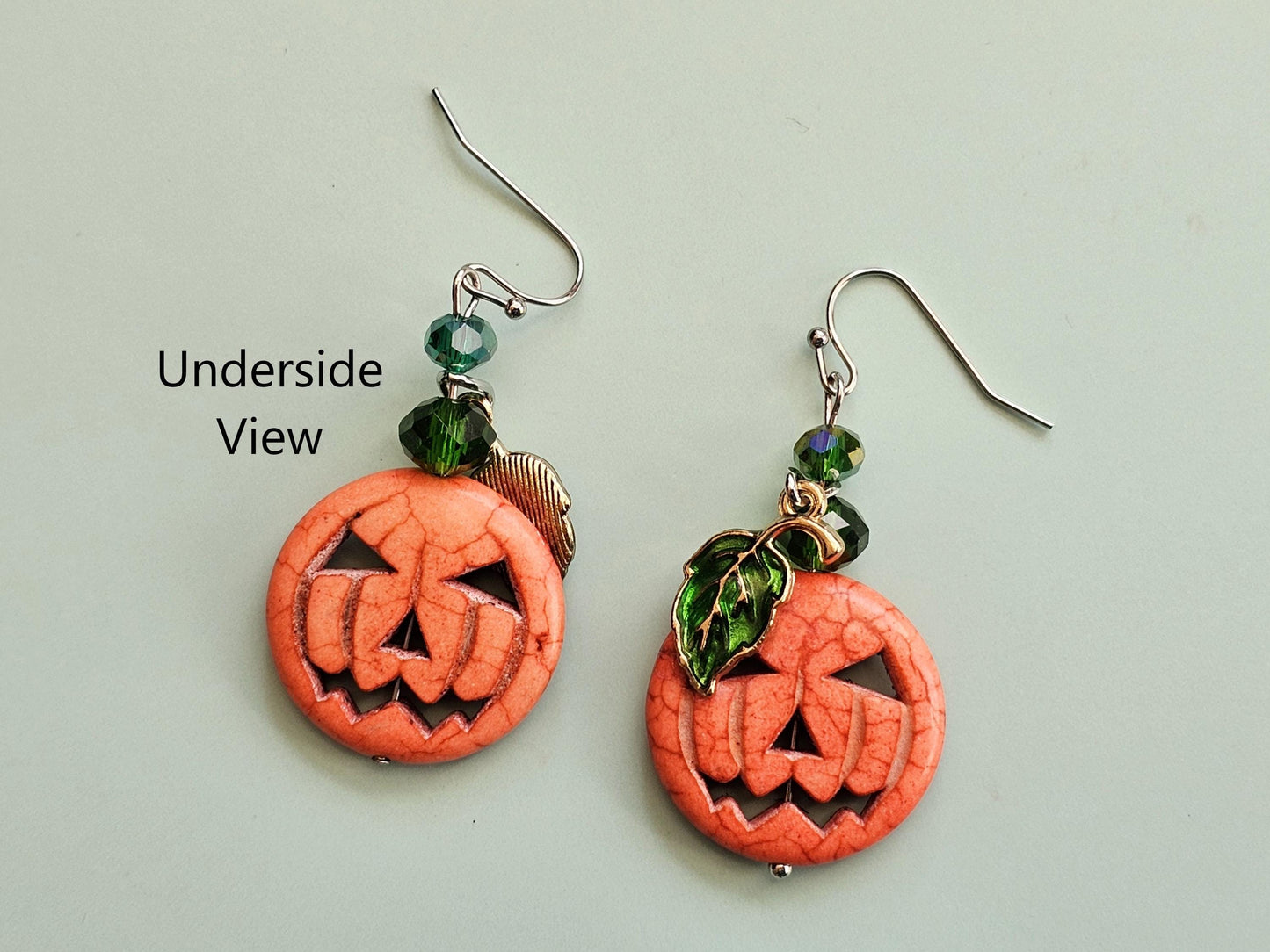 a pair of earrings with carved pumpkins on them