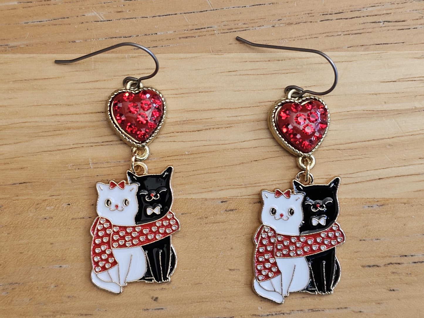 a pair of earrings with cats on them