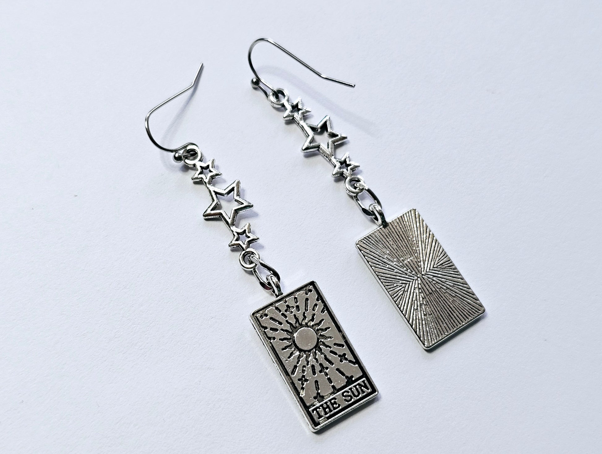 a pair of earrings with a playing card on them