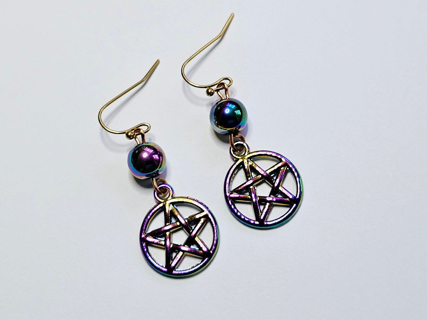 a pair of earrings with a pentagramil on it