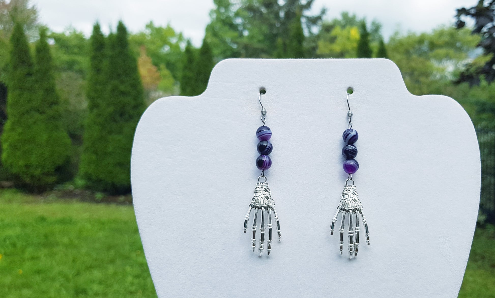 a pair of silver and purple beaded hand earrings