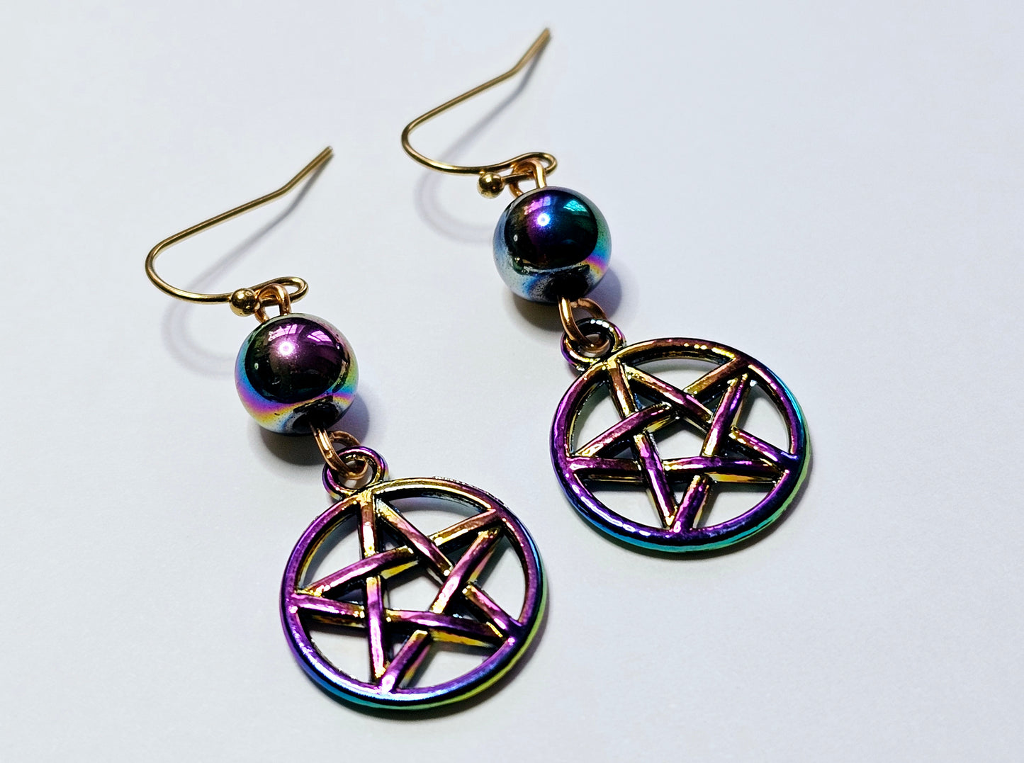 a pair of earrings with a pentagramil on it