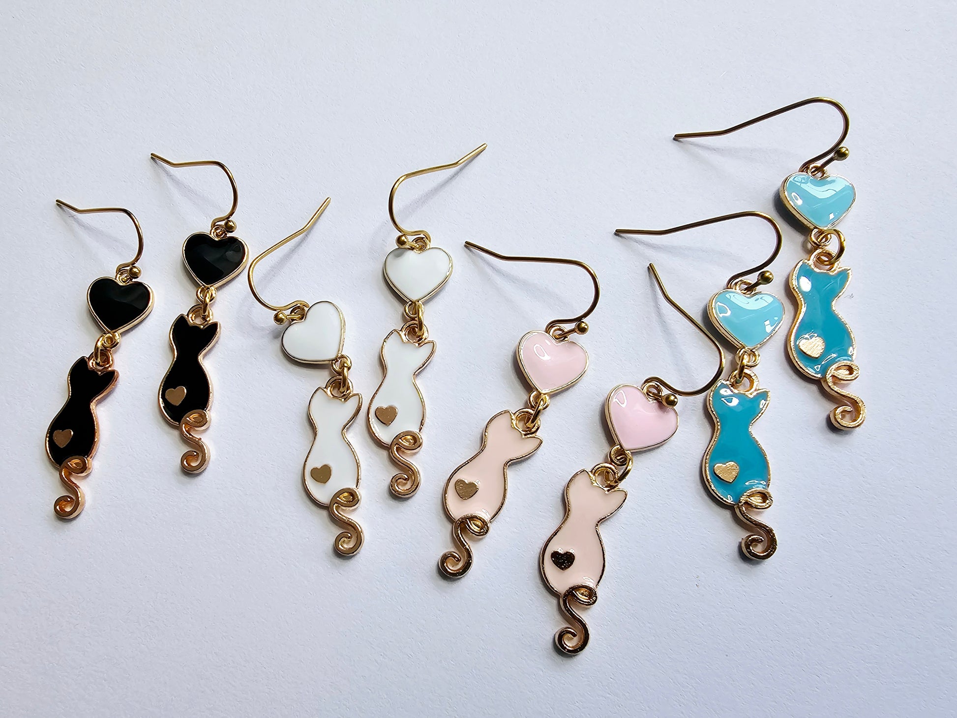 a group of five pairs of earrings sitting on top of a table