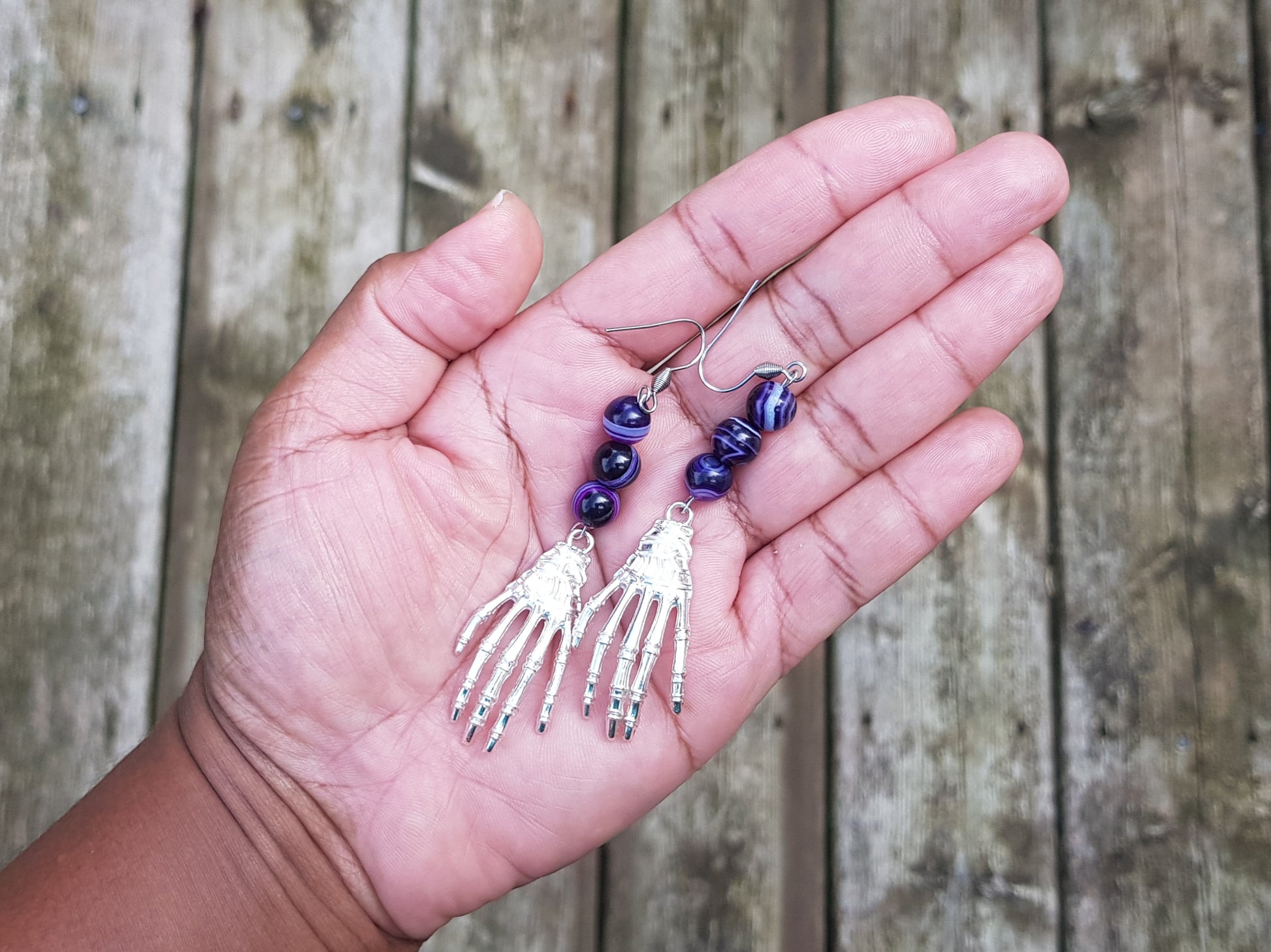 a person holding a pair of earrings in their hand