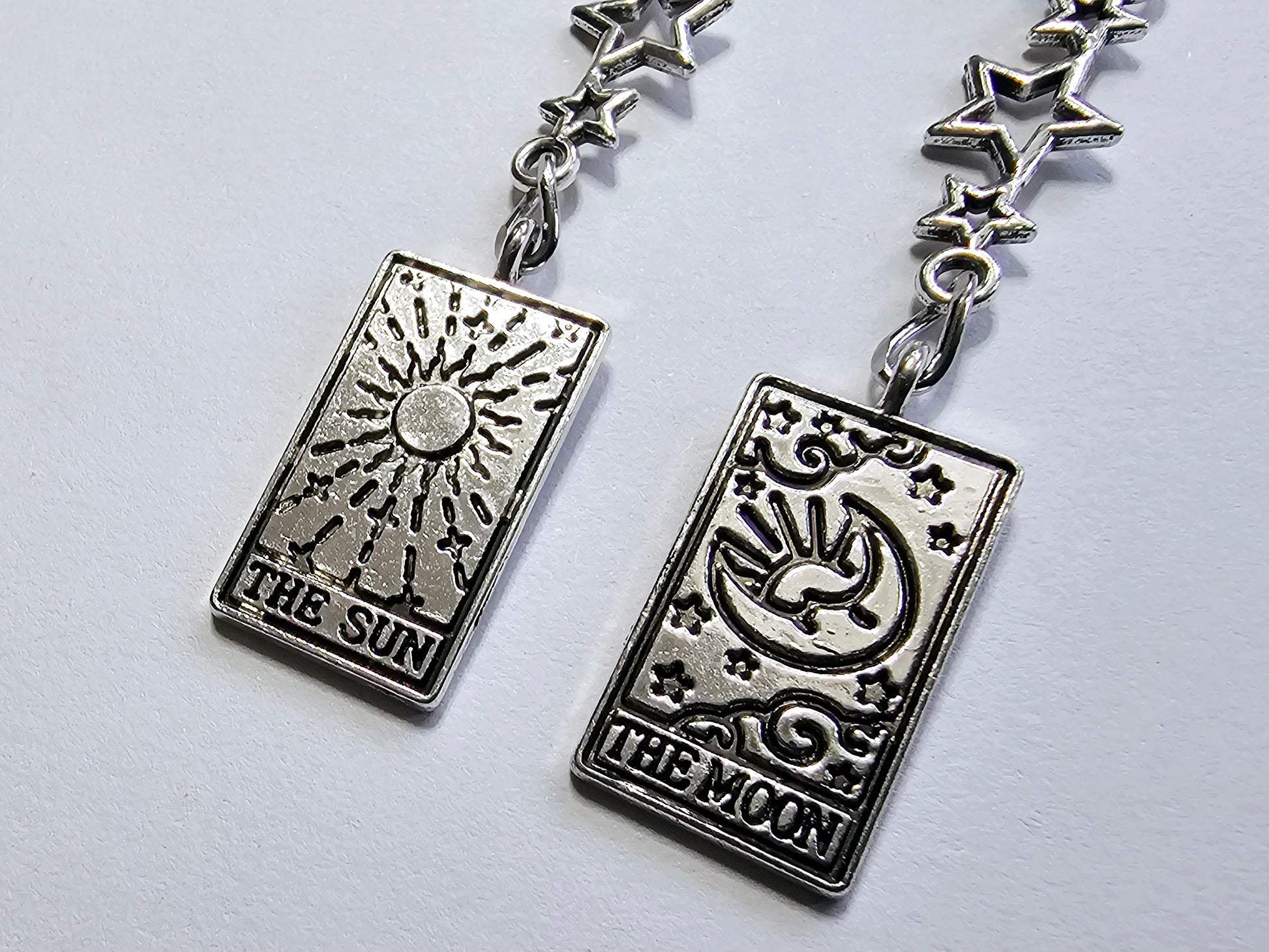 a pair of earrings with the sun and moon on them