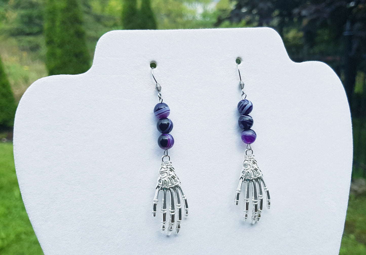 a pair of earrings with a hamsa hanging from it