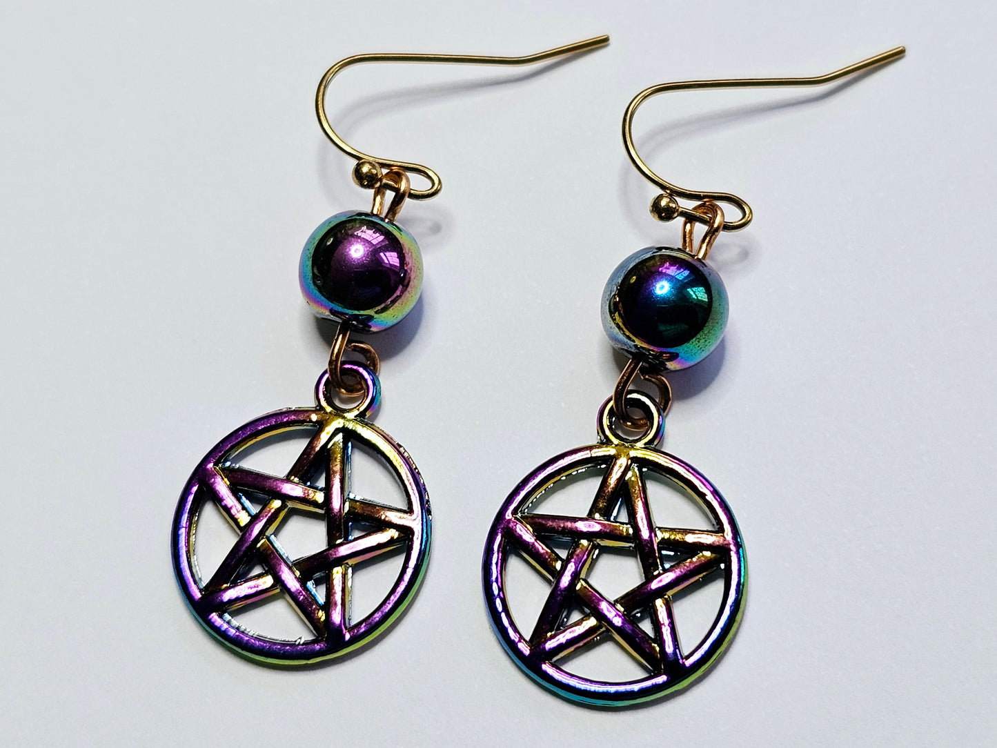 a pair of earrings with a pentagramil on it