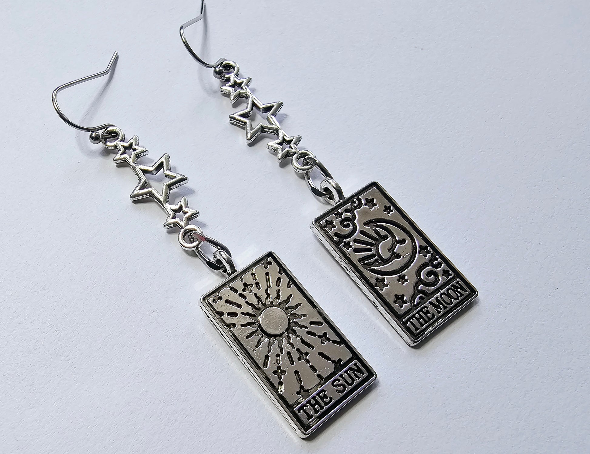 a pair of earrings featuring a playing card