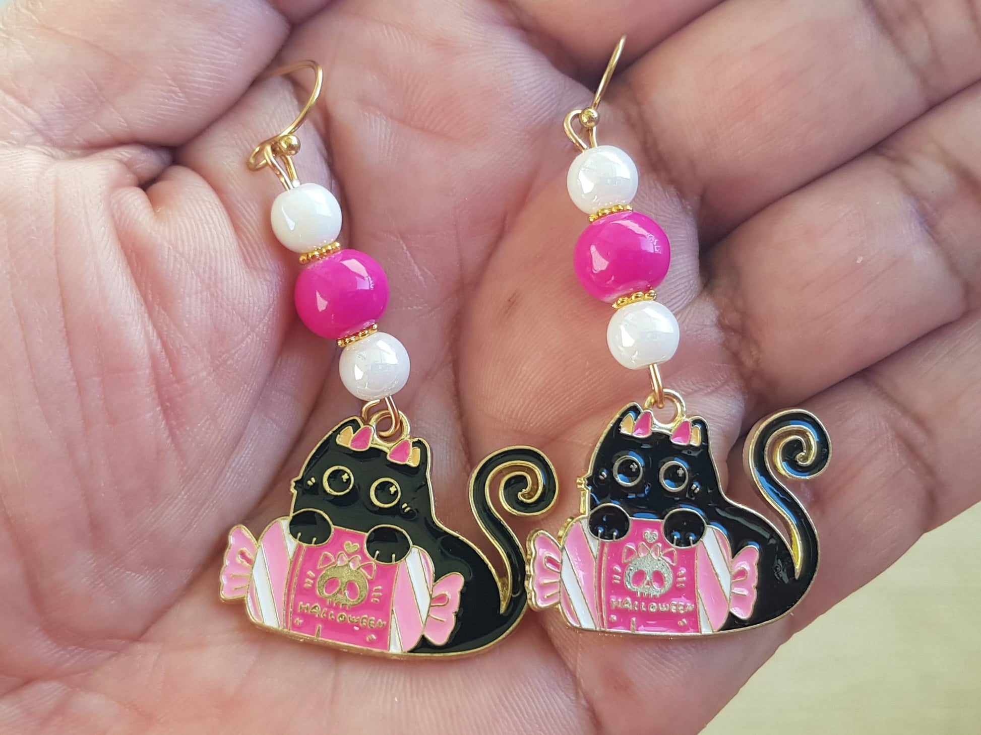 Halloween candy cat earrings with pink and white beads.