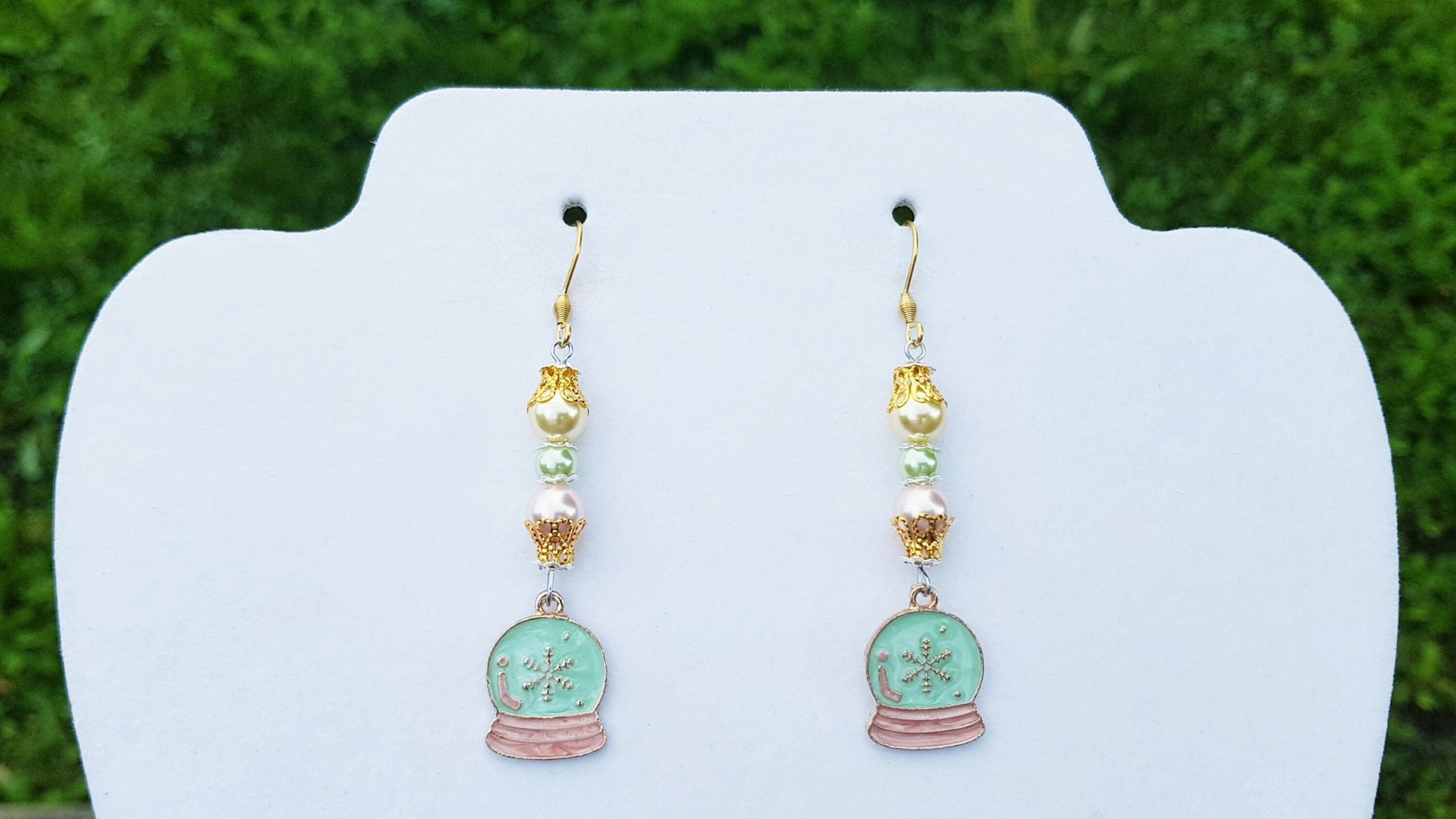 Snow globe dangle earrings with pastel coloured pearls and gold highlights.