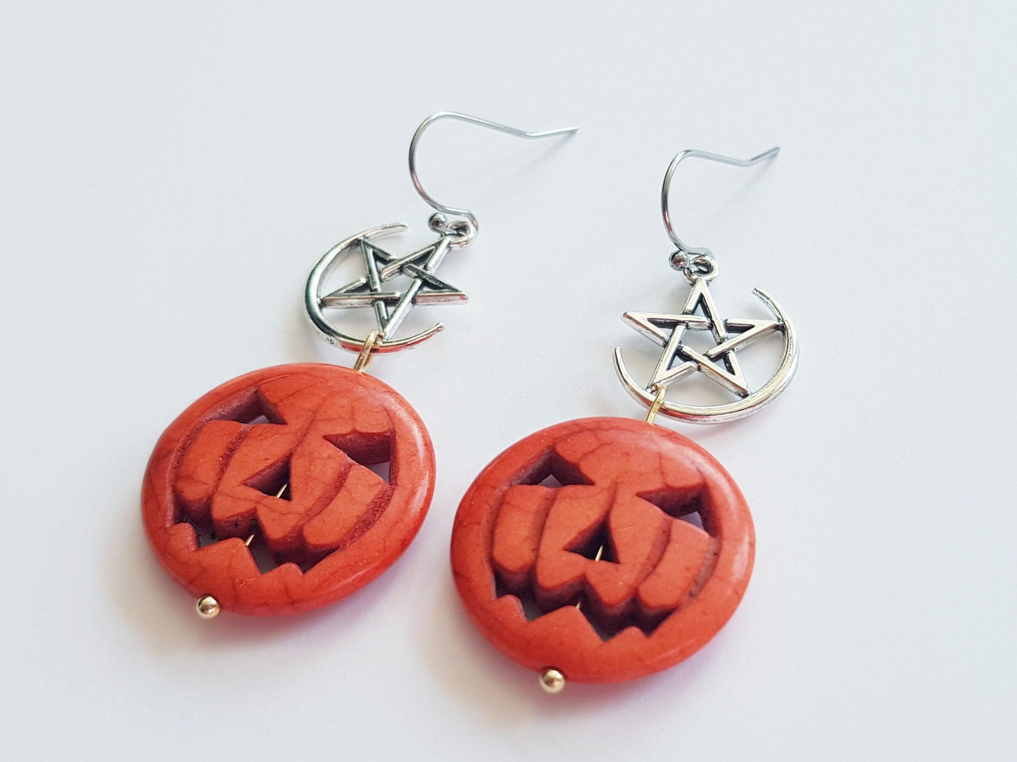 Orange and silver earrings with gold highlights.