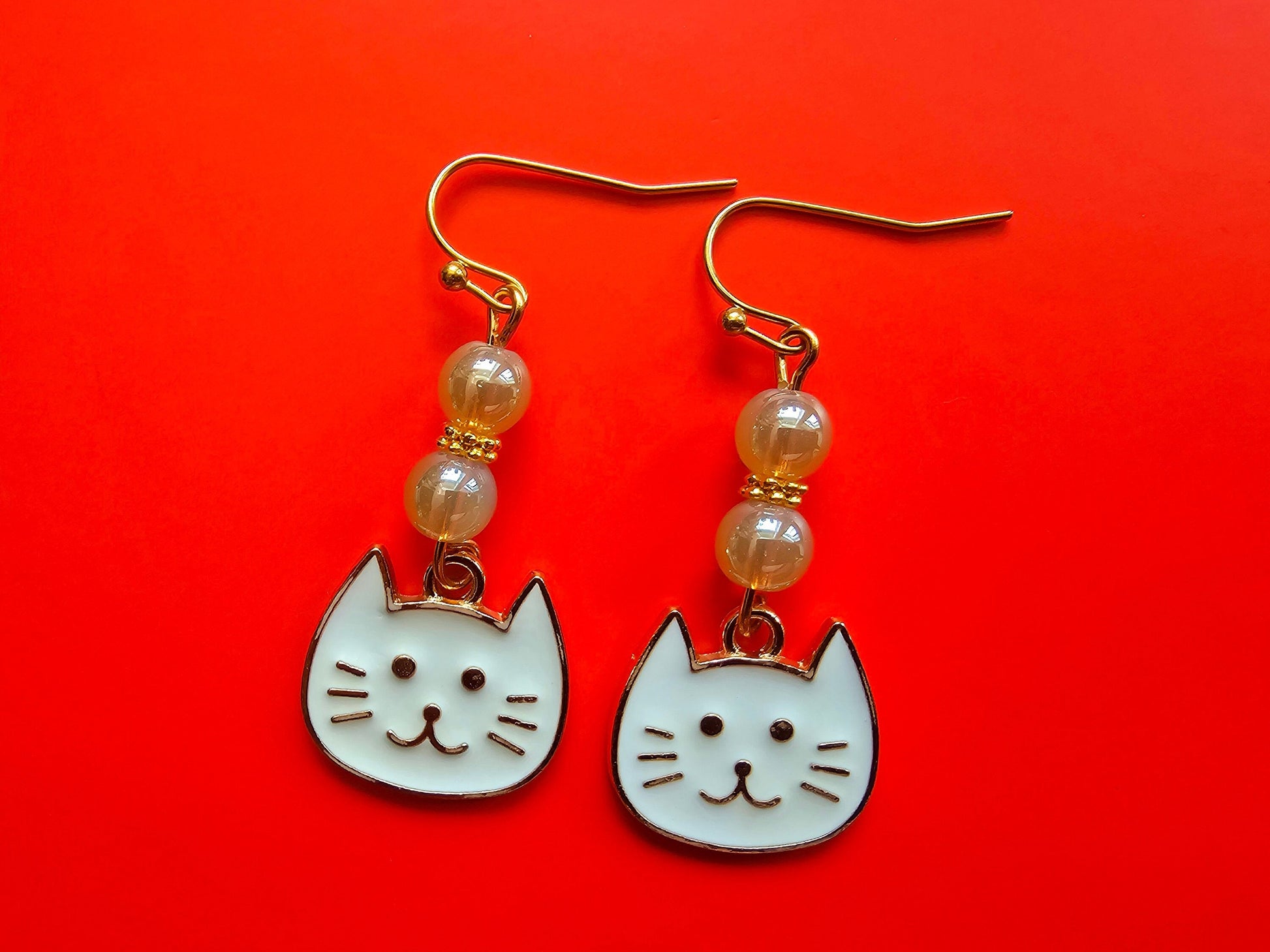 Cute white cat face earrings with hypoallergenic ear wires.