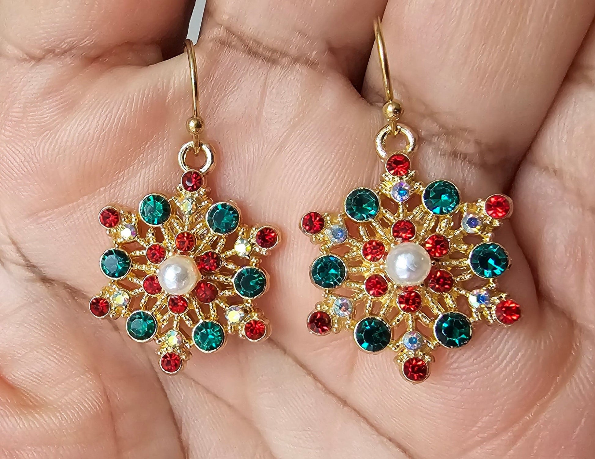 Sparkling snowflake earrings in red, green, white and gold.